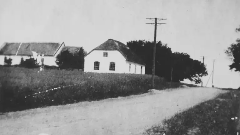Billedet viser Tolne skole, I baggrunden kirken, ca. 1930